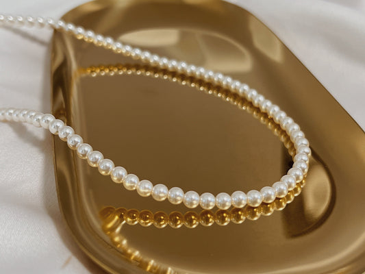 Marianna tiny pearl choker necklace displaying micro genuine freshwater pearls on gold tray