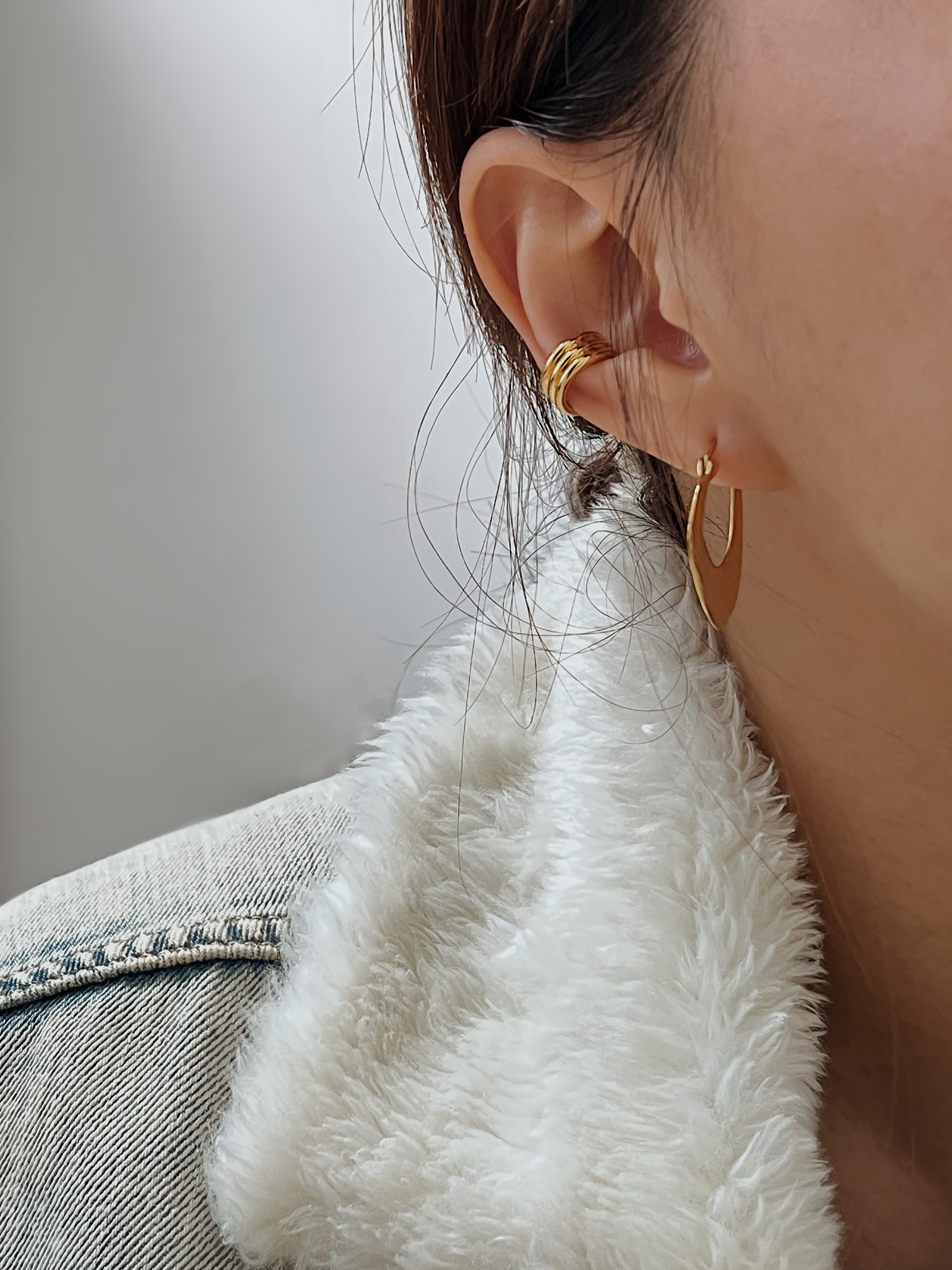Model wearing Elena triple gold cuff in the conch for a bold layered look.