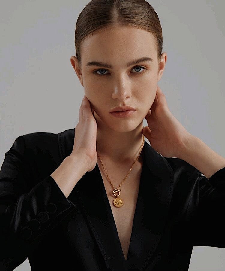 Lifestyle shot of waterproof 18K gold medallion necklace highlighting the front toggle closure.