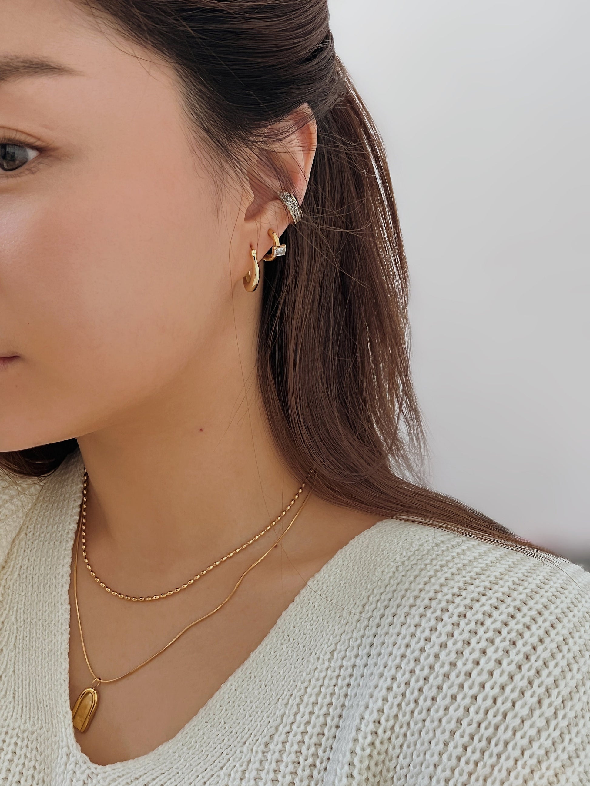 Multi-layered ear stack featuring Priscilla Thick Cuff in gold color.