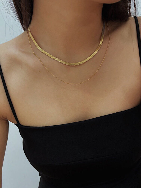 Model chest view styling the sylvie layered herringbone chain necklace against bare skin