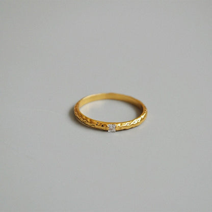 Sculptural gold ring showing high-polish reflective hammered surface