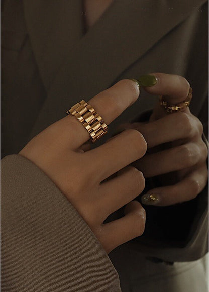 Hand model styling gold watch chain ring with a structured blazer