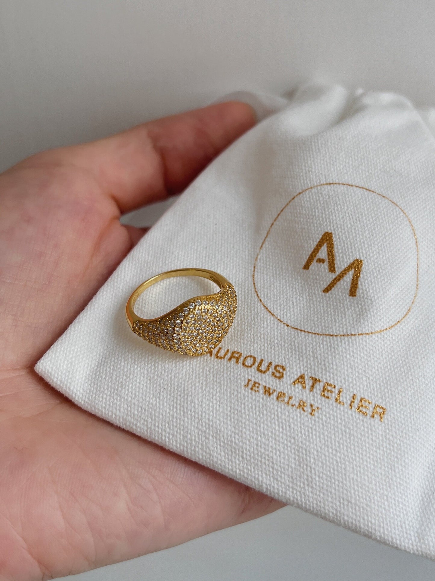 Close-up of 5A cubic zirconia pavé stones on gold signet ring.