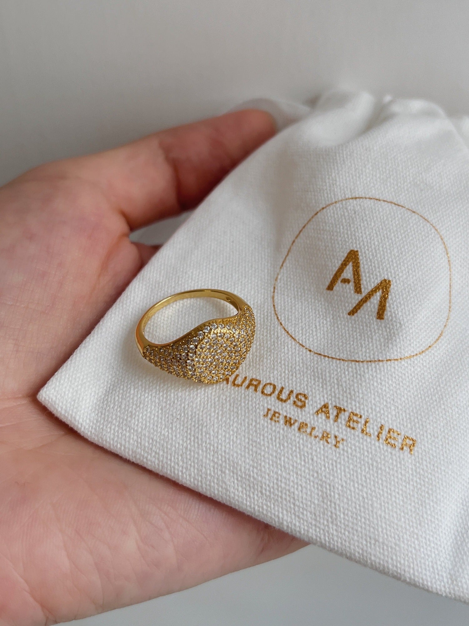 Close-up of 5A cubic zirconia pavé stones on gold signet ring.