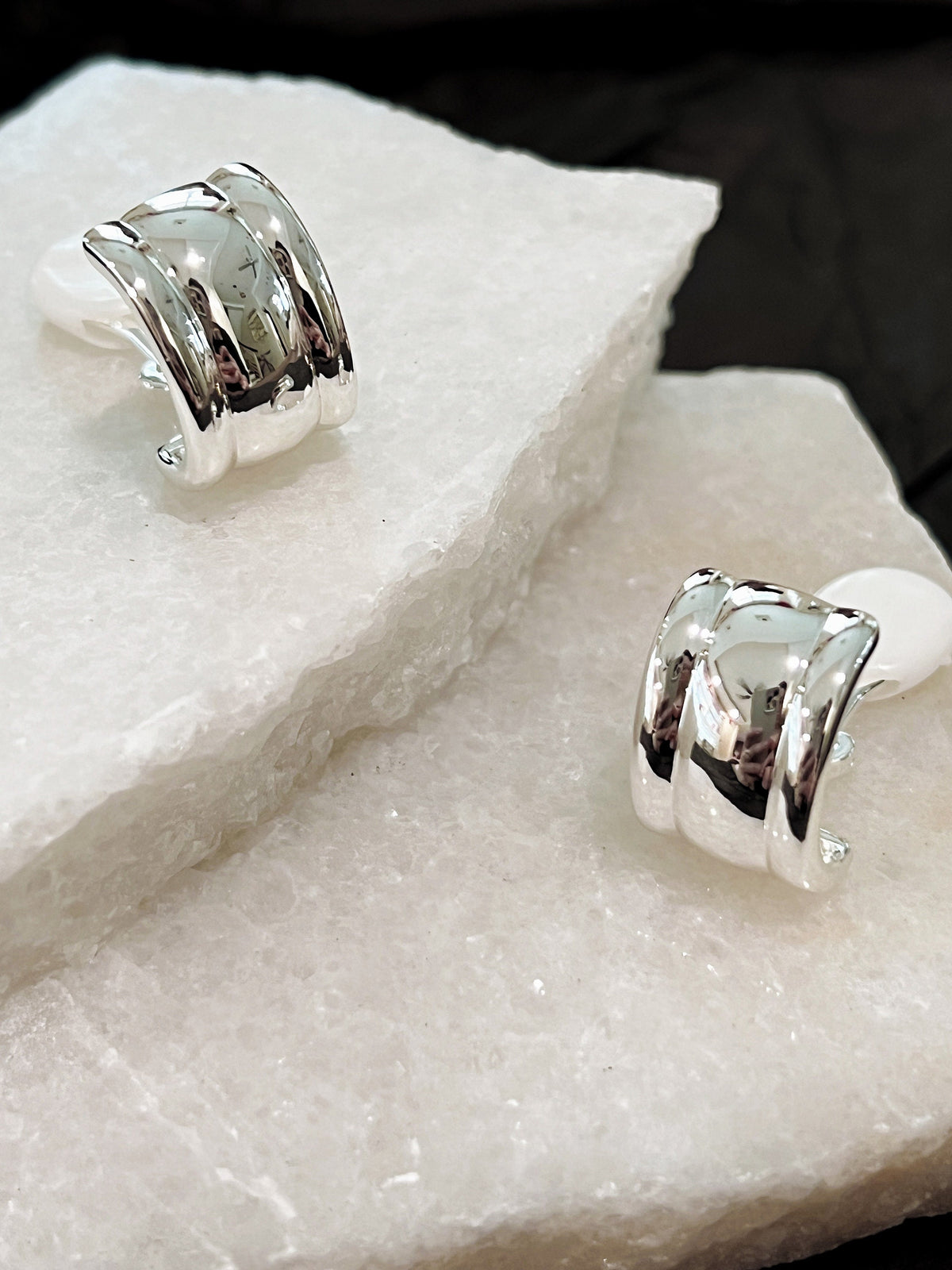 Macro detail view of silver Molly vintage clip-on earrings showcasing triple convex ribbed architecture and mirror polish finish
