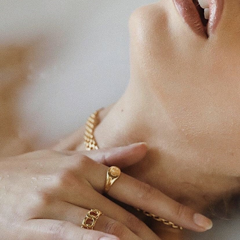 Editorial style jewelry lookbook photo highlighting high shine gold link chains stacks with other gold jewellery