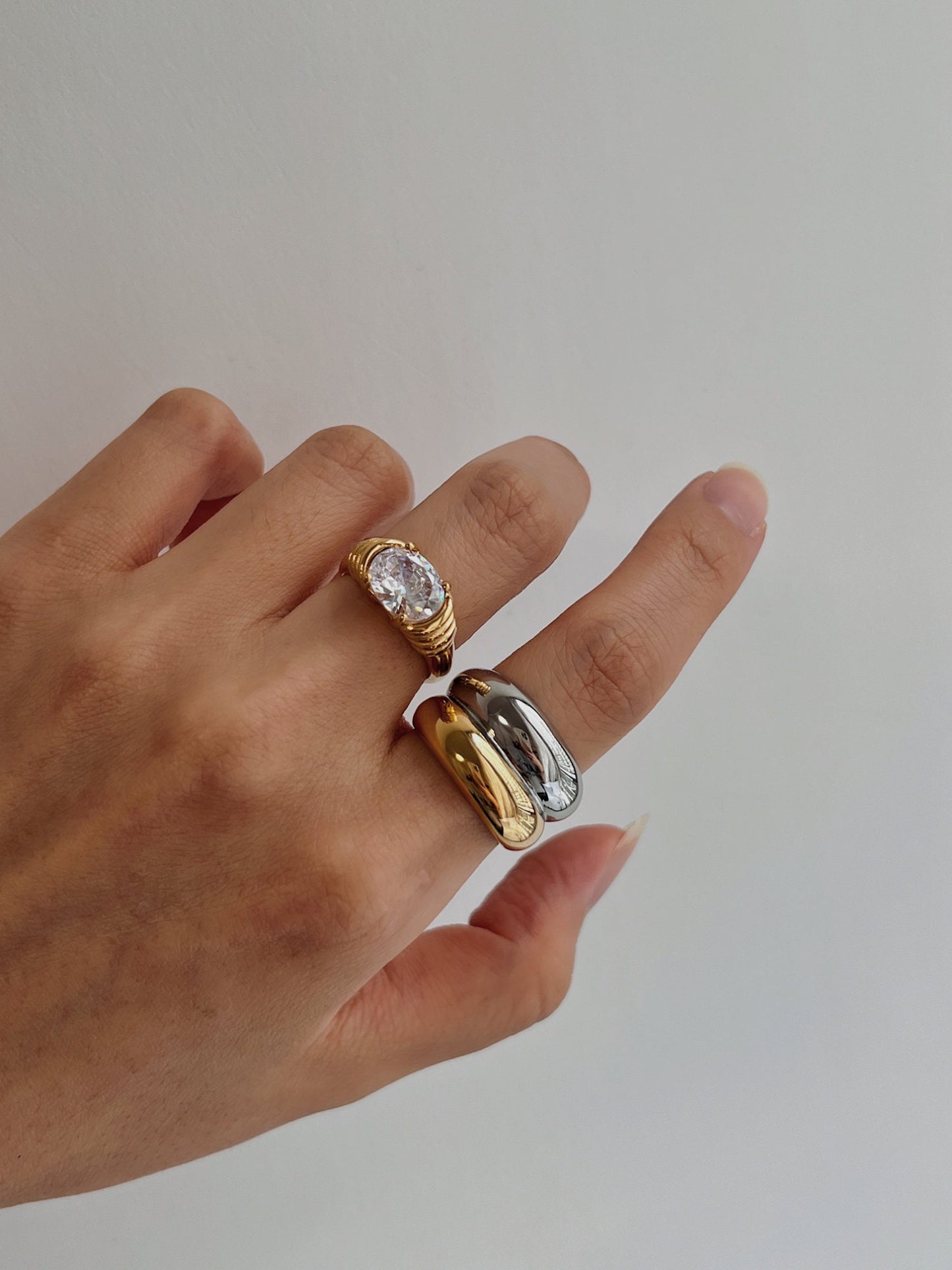 Hand model showcasing the high-contrast gold and silver ridges of the Brittany ring and chiara cz ring