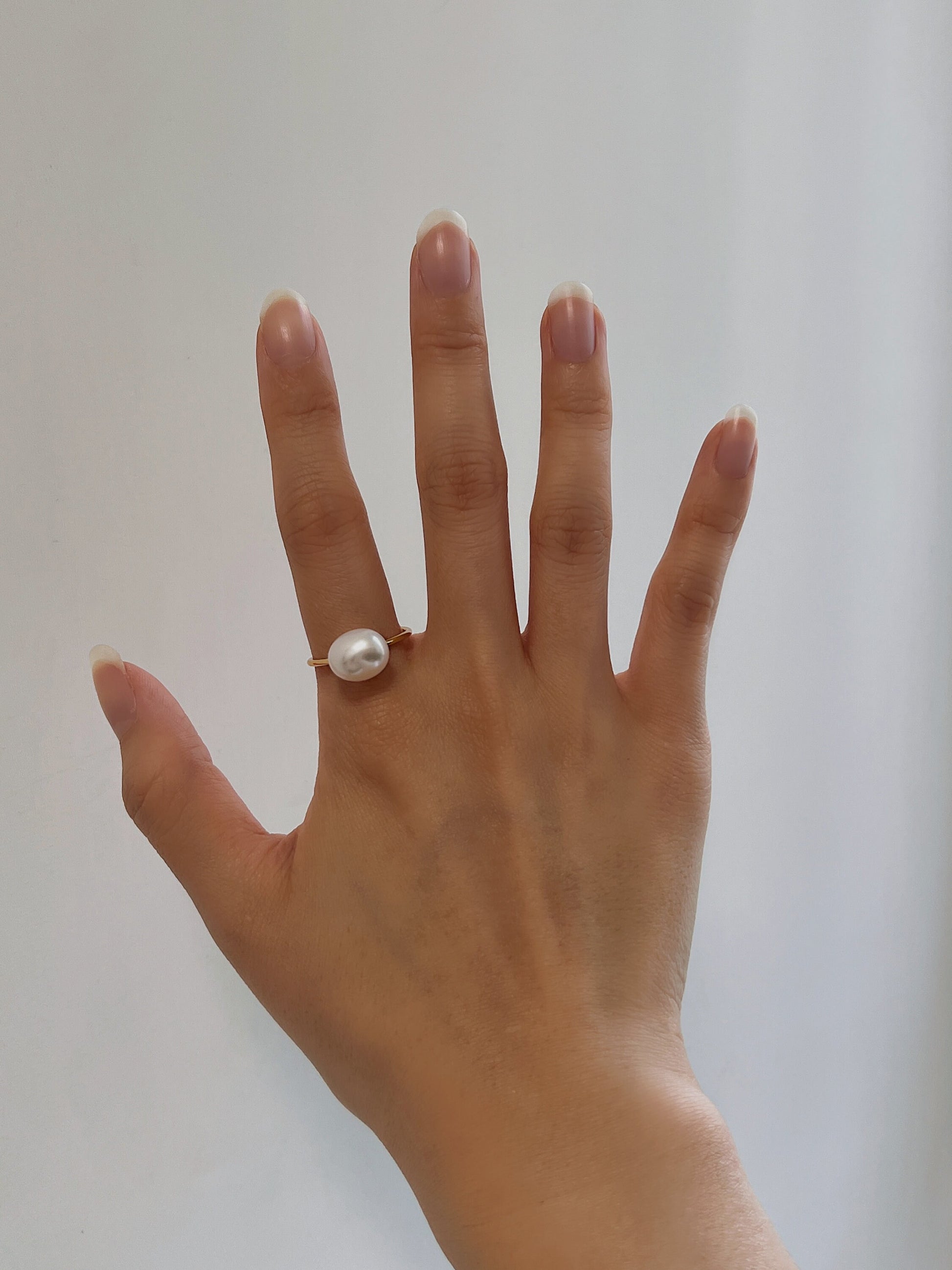 Modern jewelry ring stack featuring natural pearl rings on a model