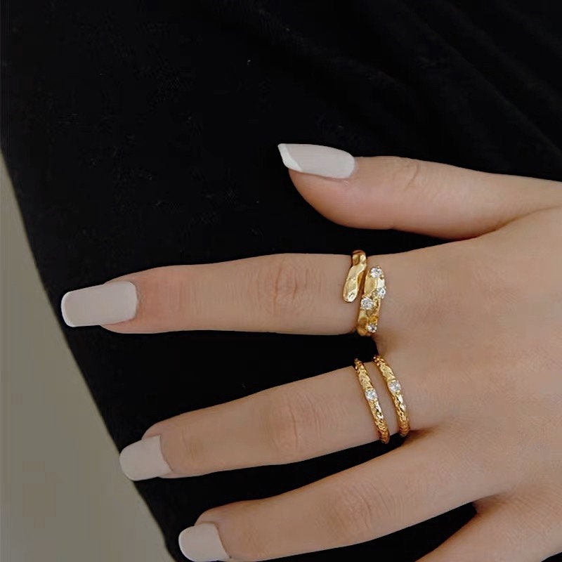 Close up of hand with the Doris asymmetrical ring and minimalist gold bands