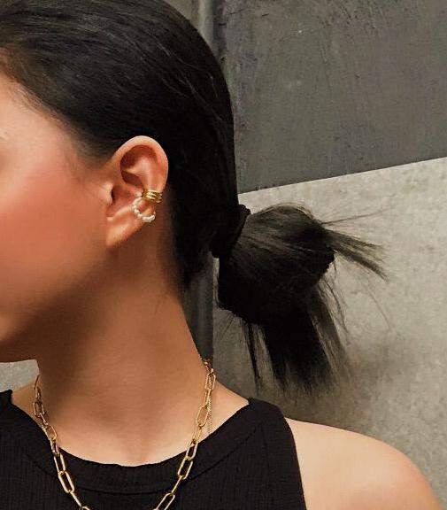 Quiet luxury ear stack on a model featuring the Elena 18K gold PVD cuff.