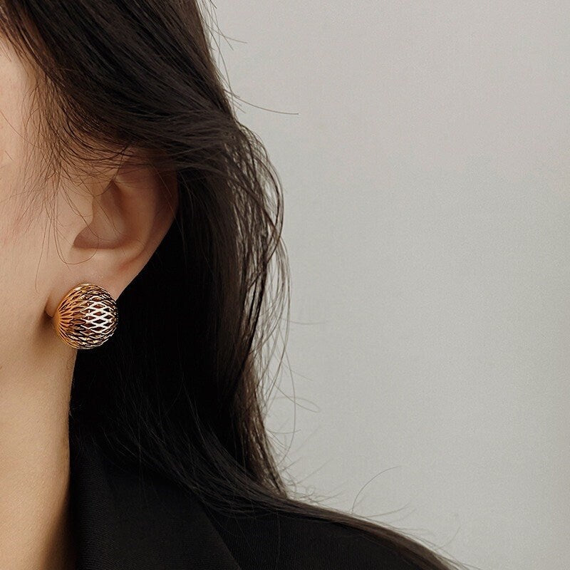 Direct earlobe profile showing how the 17mm gold woven dome clip-on sits flush without dragging the lobe down.