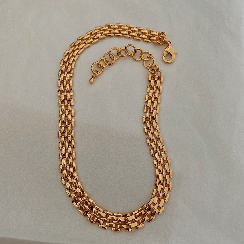 Sean panther link chain necklace displaying wide gold brick link profile on white surface