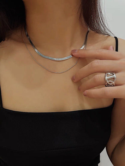 lifestyle jewelry lookbook photo highlighting high shine silver chains on black camisole