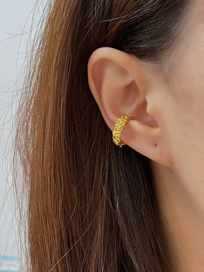 Model wearing the Molten Ridge gold PVD ear cuff with a sleek hair down hairstyle to highlight the ear stack.