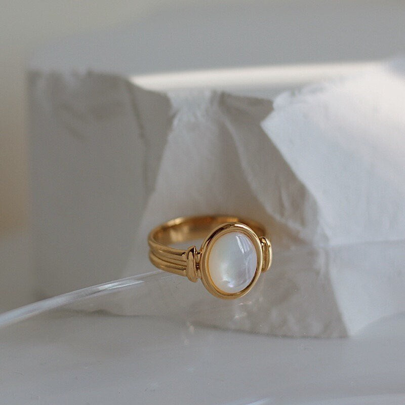 Architectural ribbed gold band with sea-inspired gemstone center