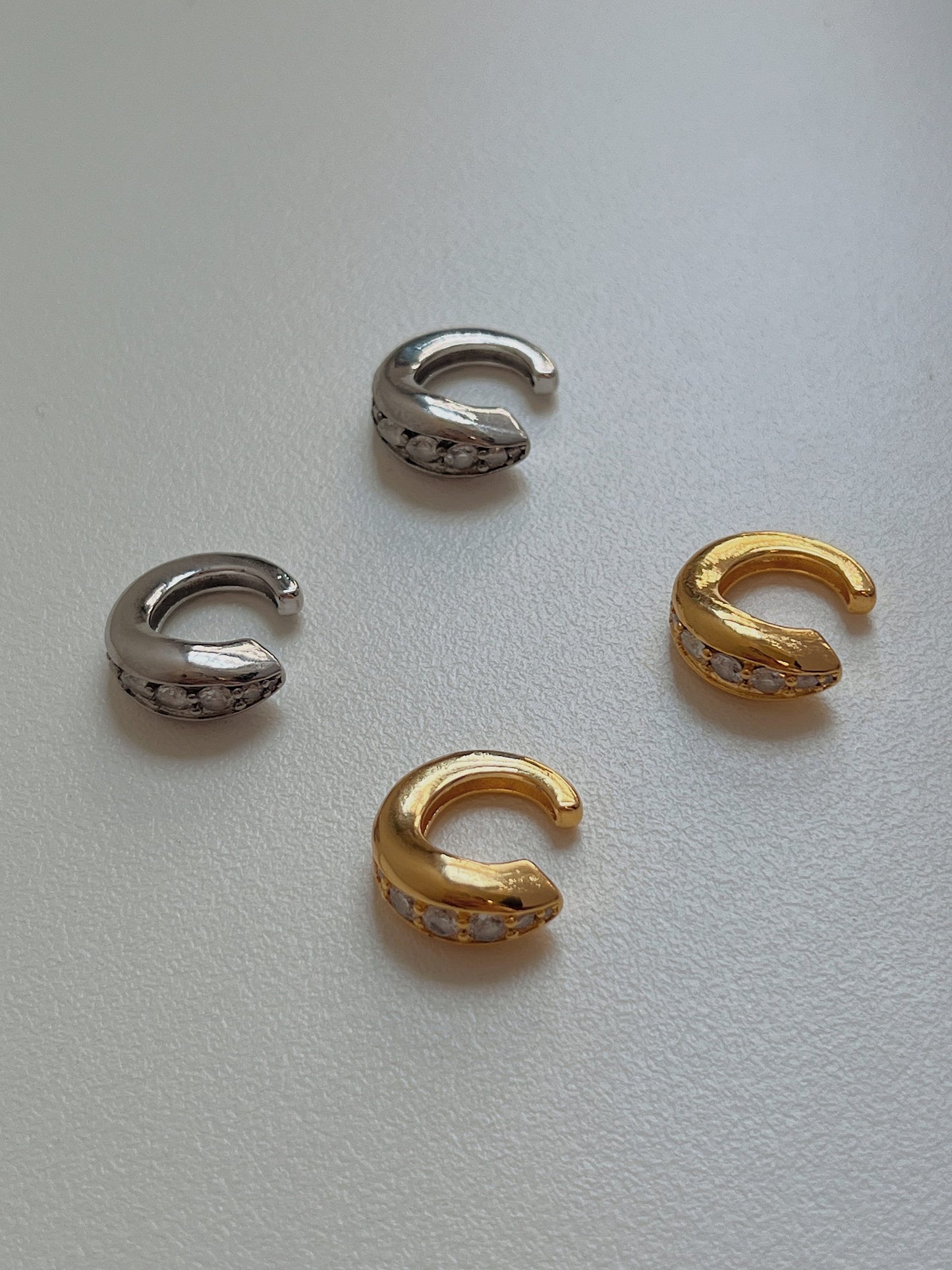 Front view of Marissa ear cuff in gold and silver on a natural lighting.