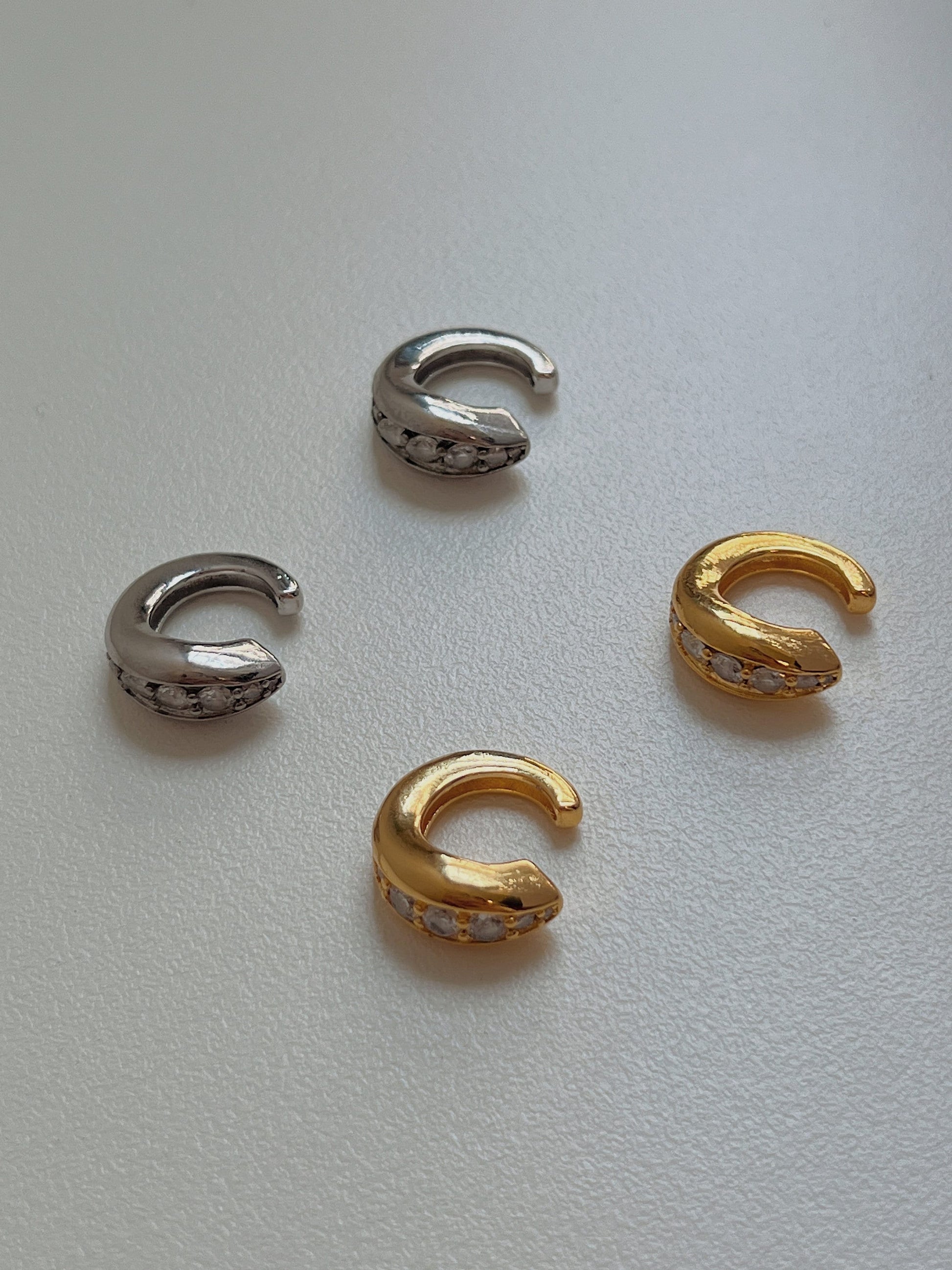 Front view of Marissa ear cuff in gold and silver on a natural lighting.