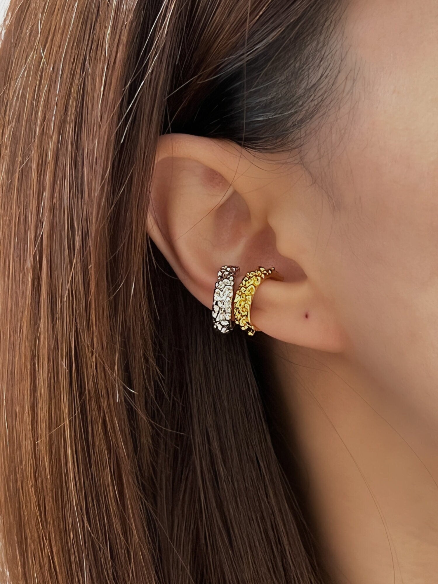 Model wearing the Molten Ridge textured gold ear cuff styled with Molten Ridge textured silver ear cuff
