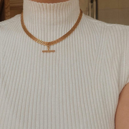 Woman neckline displaying modern 18k gold PVD stacked hardware chains placement look